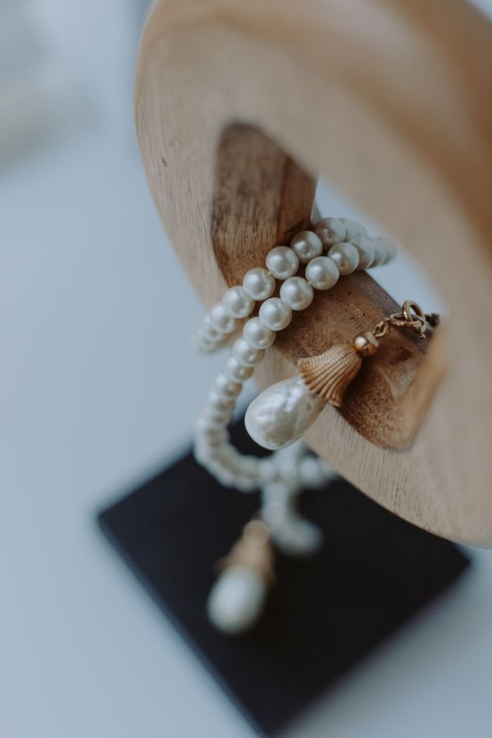 Elegant pearl jewelry draped over a wooden stand, showcasing luxury and sophistication.