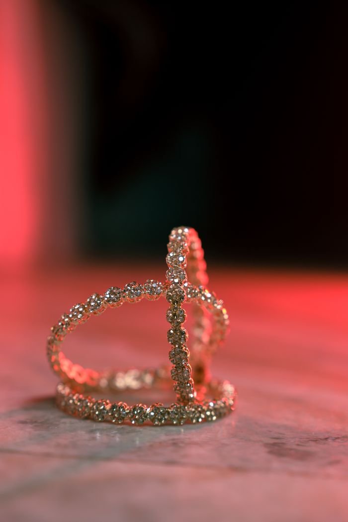 A stunning rhinestone tiara with sparkling jewels displayed on a marble surface under dramatic lighting.