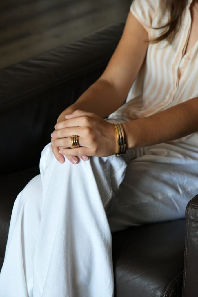 Crafting Captivating Headlines: Your awesome post title goes here Close-up of a woman's hands adorned with jewelry, resting on her lap in casual attire.